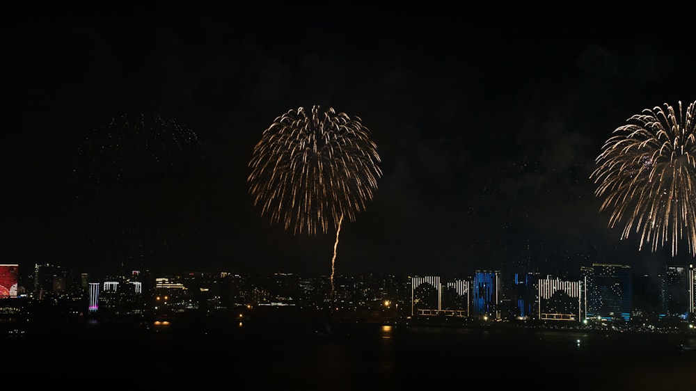 fireworks are lit up in the night sky over a city