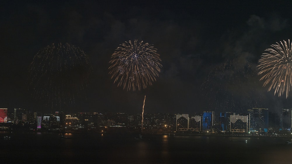 fireworks are lit up in the night sky over a city