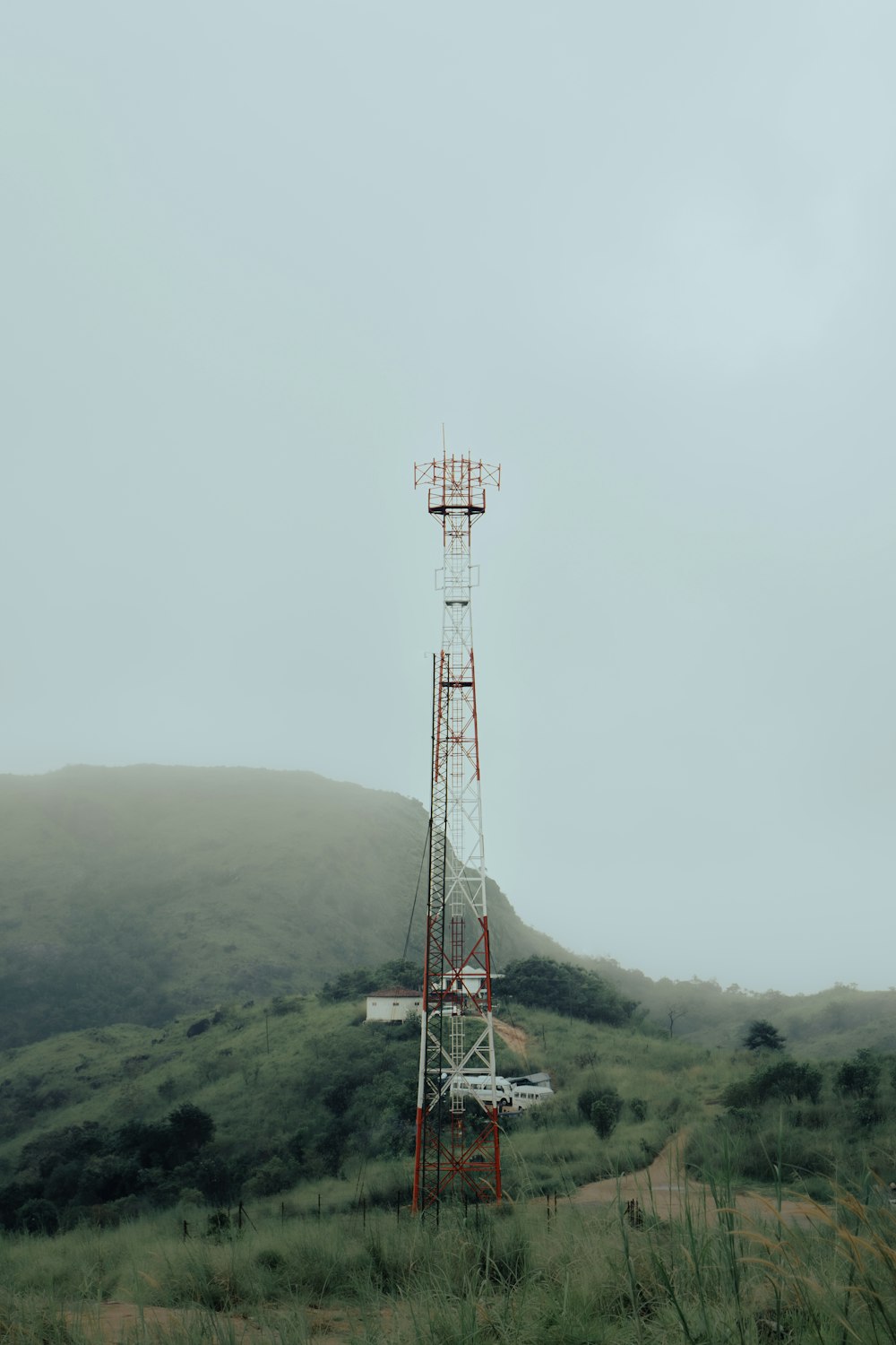 a radio tower sitting on top of a lush green hillside