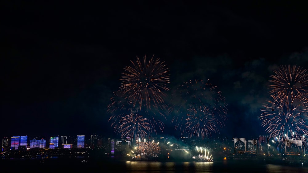 fireworks are lit up in the night sky over a city