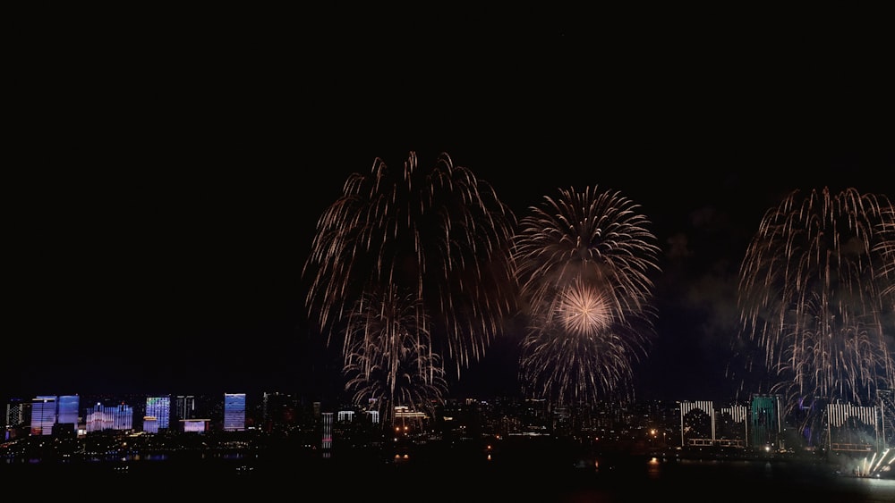 fireworks are lit up in the night sky over a city