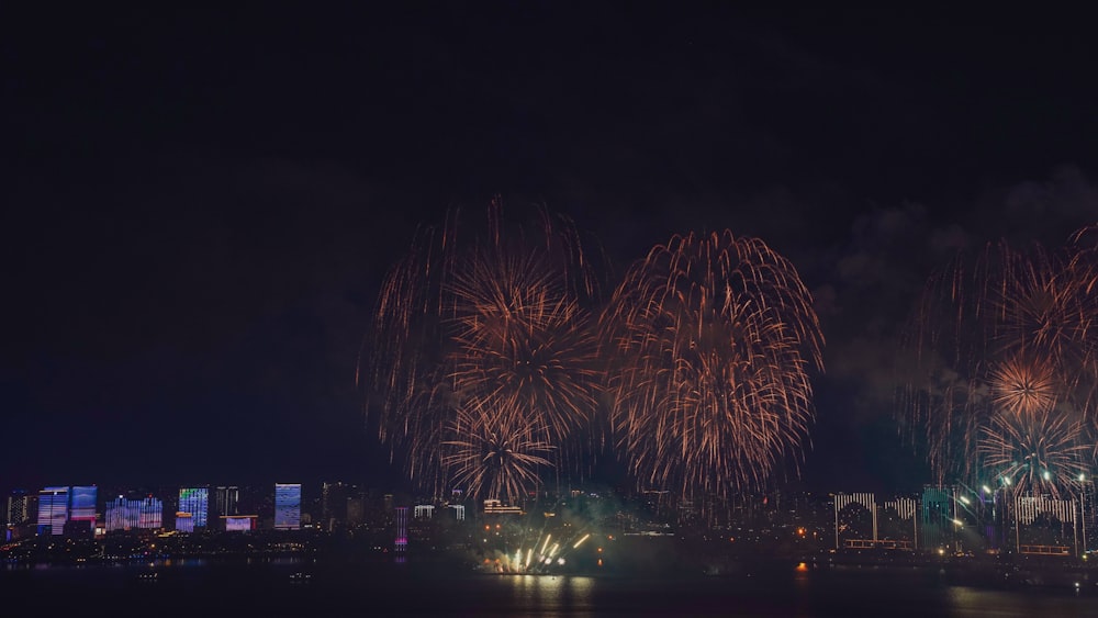 fireworks are lit up in the night sky over a city