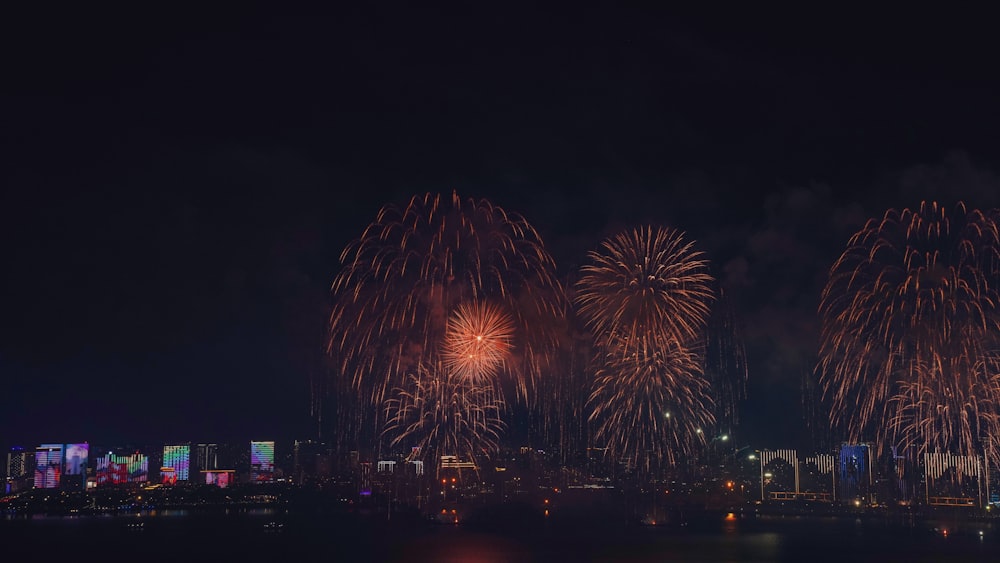 fireworks are lit up in the night sky over a city