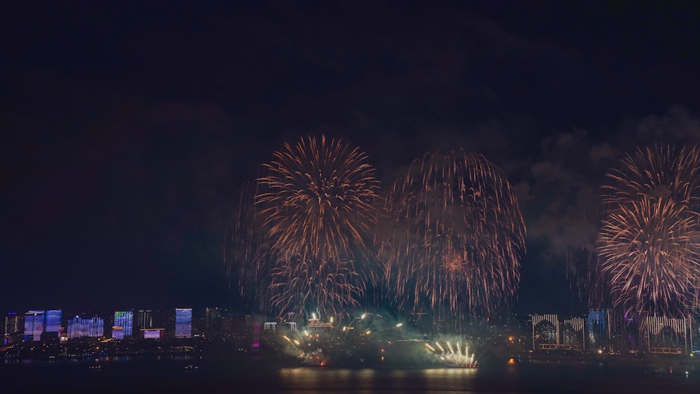 fireworks are lit up in the night sky over a city