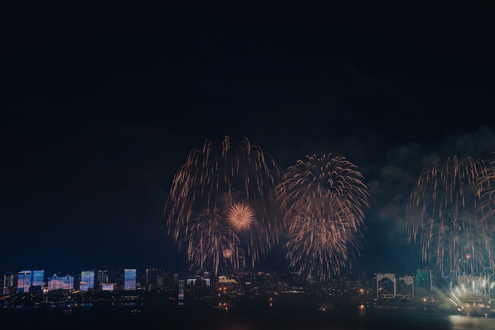 fireworks are lit up in the night sky over a city