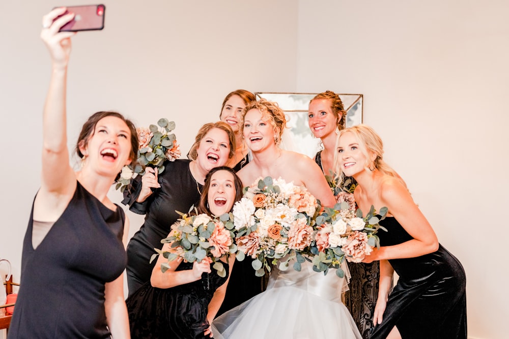 a group of women taking a picture with a cell phone