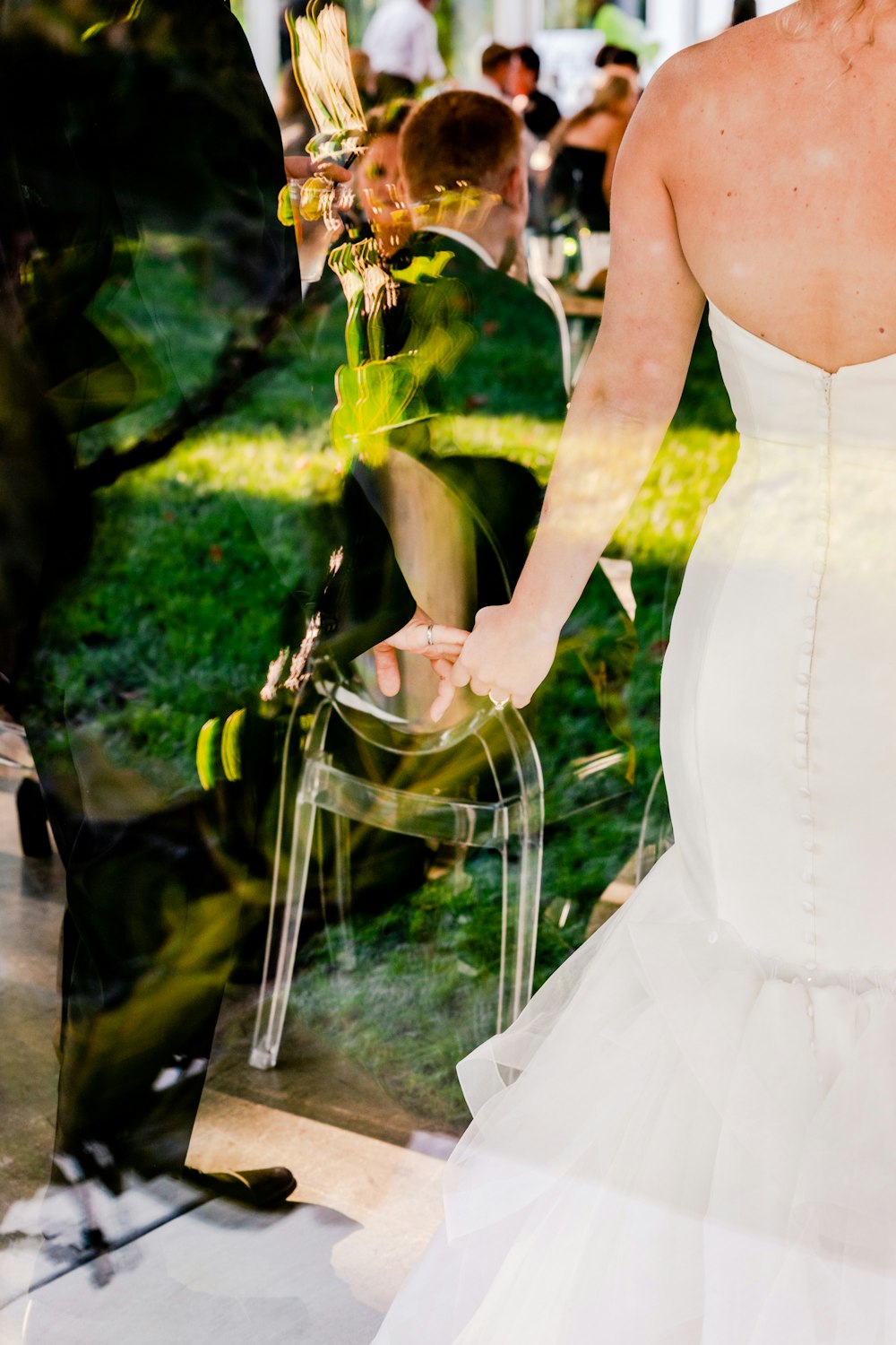 a bride and groom walking through a park