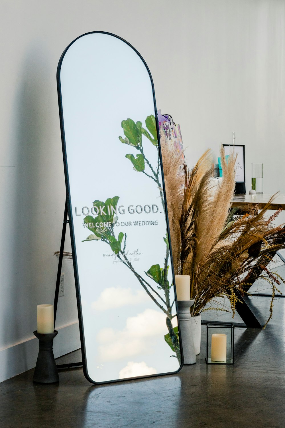 a tall mirror sitting on top of a wooden table