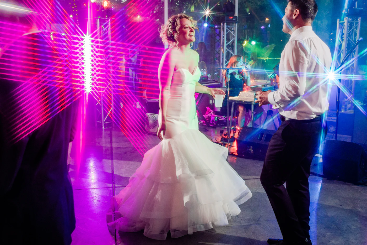 DIY dance floor decals for personalized reception spaces — Guests dance on a personalized dance floor featuring the couple's names and wedding date.