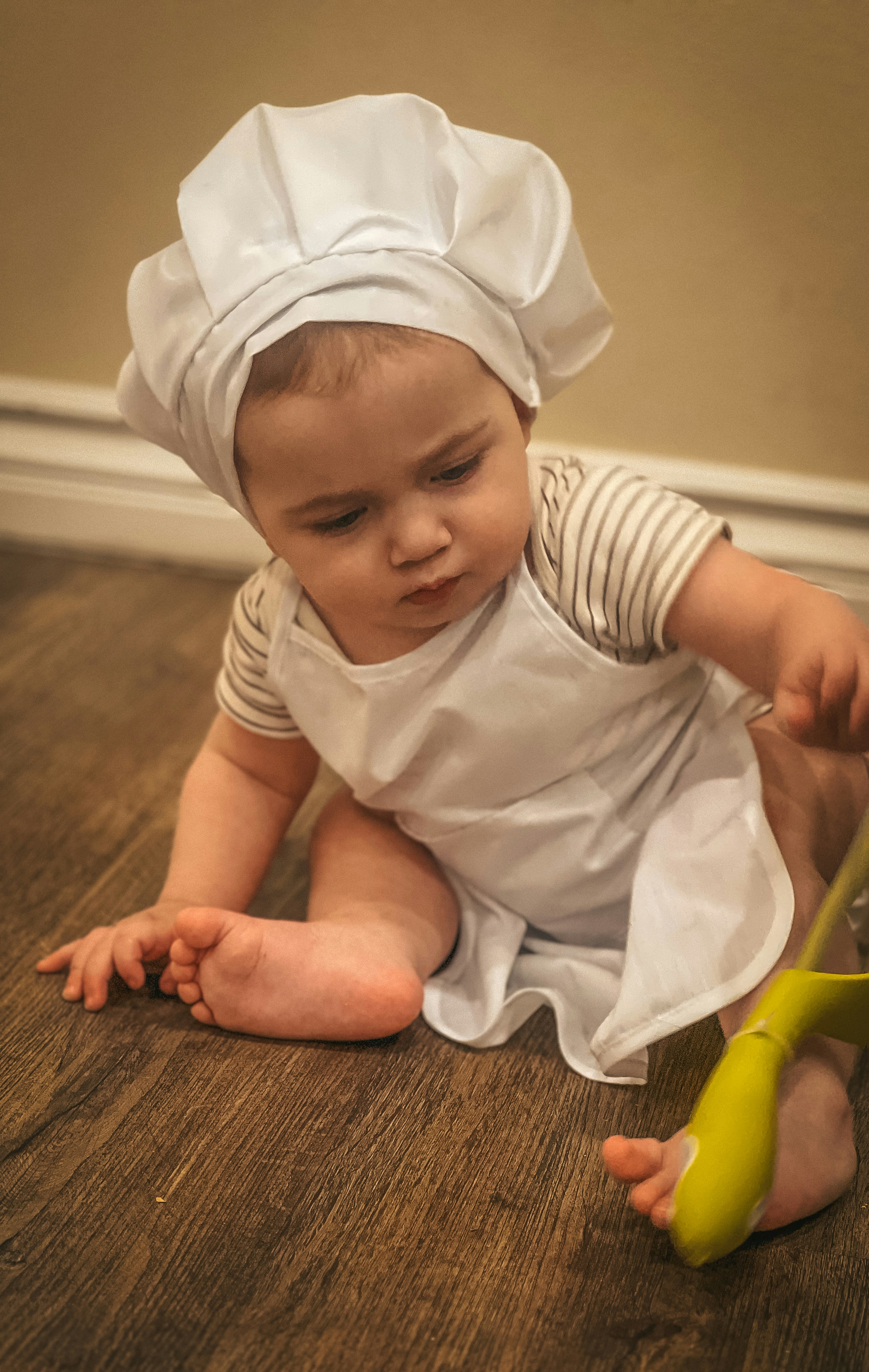 a baby sitting on the floor playing with a toy