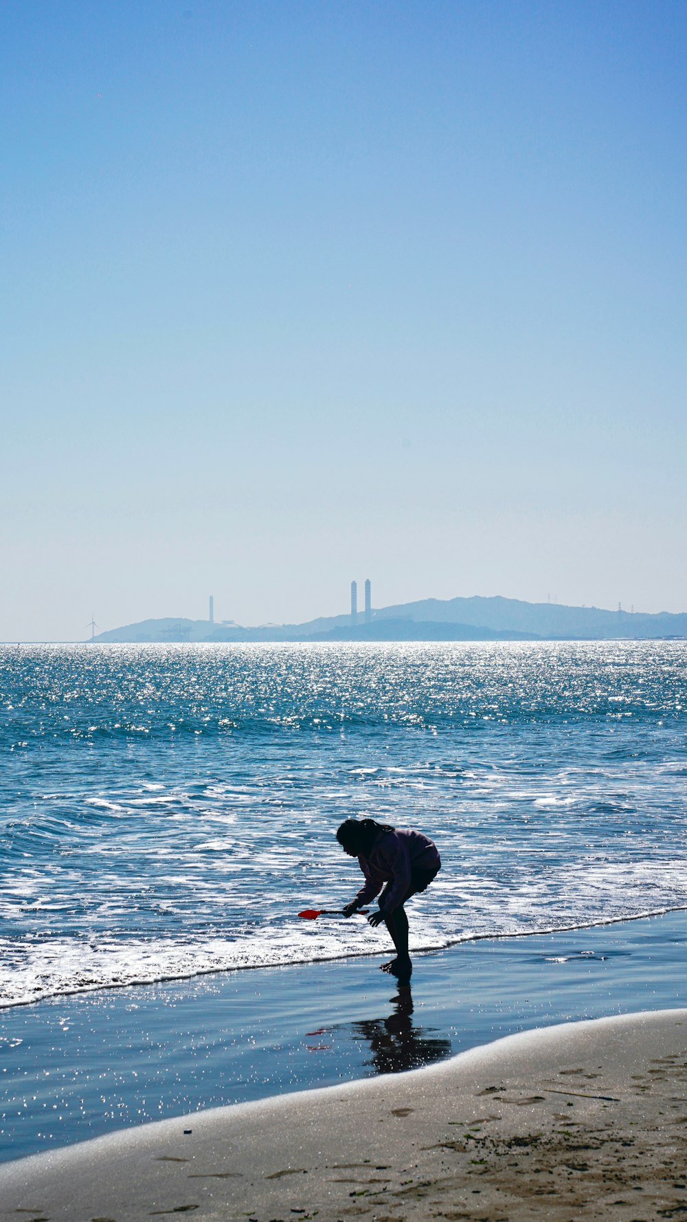 a person standing on a beach next to the ocean