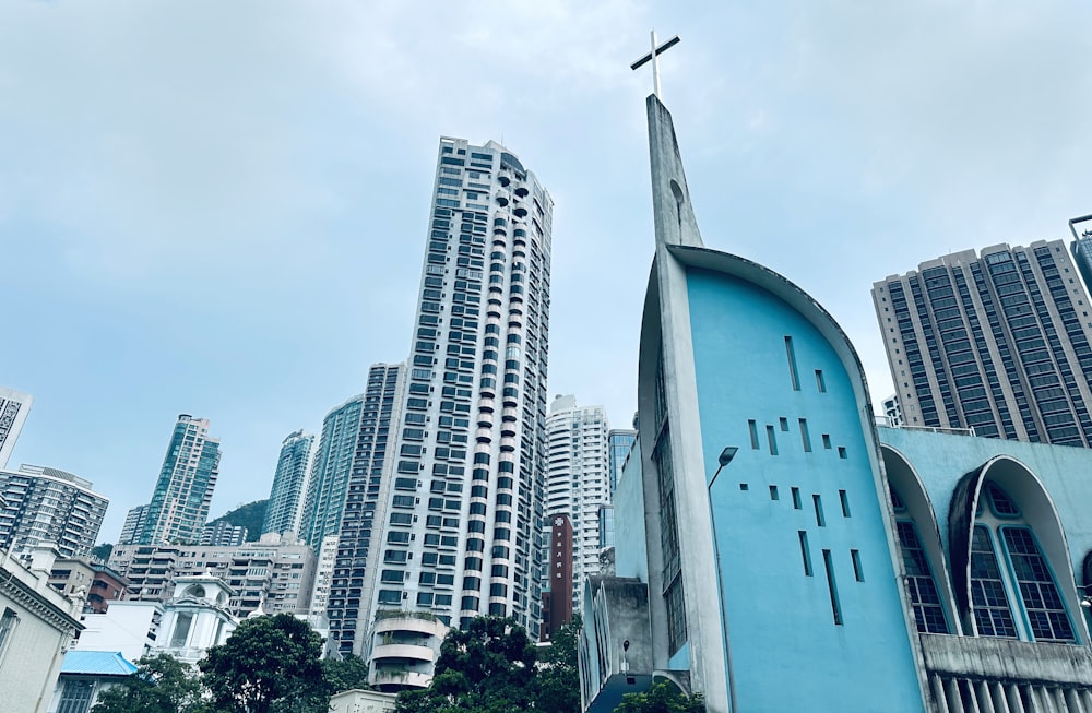 a blue church with tall buildings in the background
