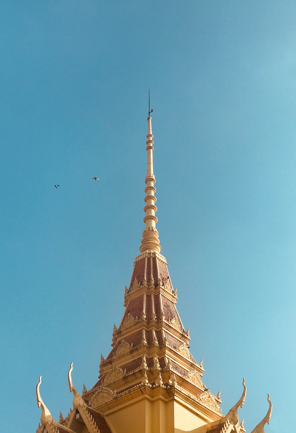 un bâtiment doré avec un oiseau volant dans le ciel