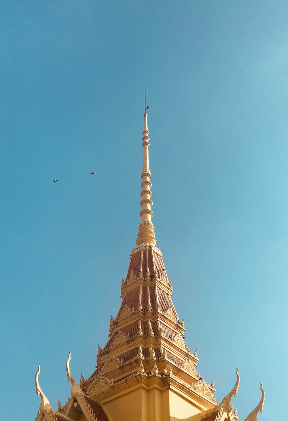 a golden building with a bird flying in the sky