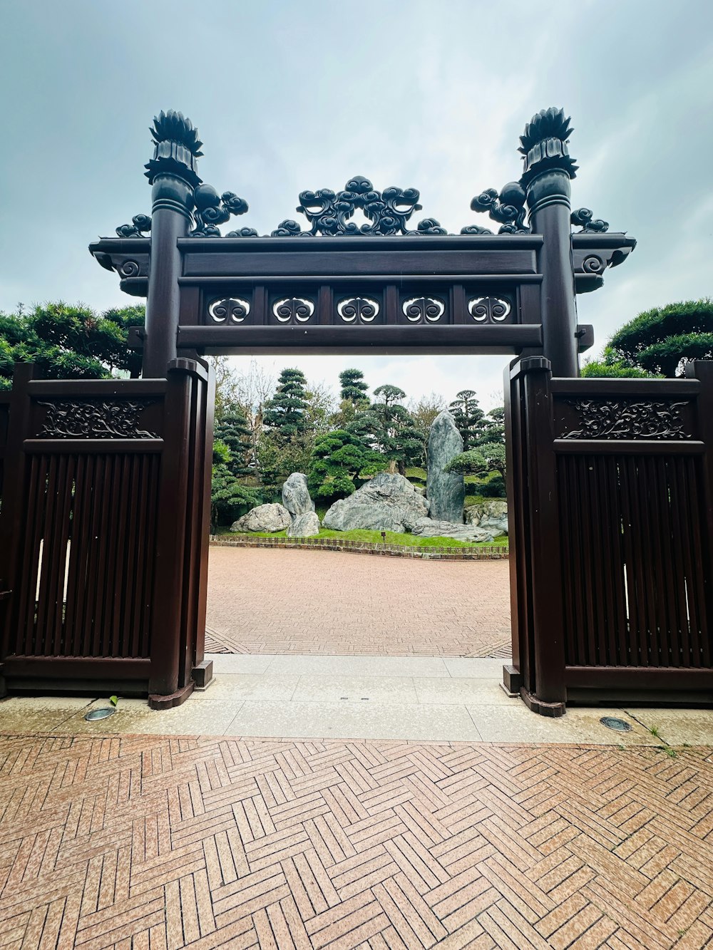 a wooden gate with a brick walkway in front of it