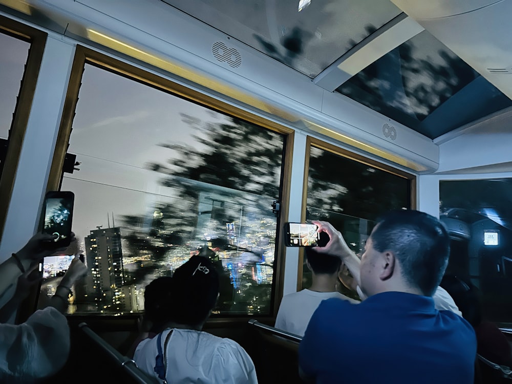 a group of people taking pictures of a city at night