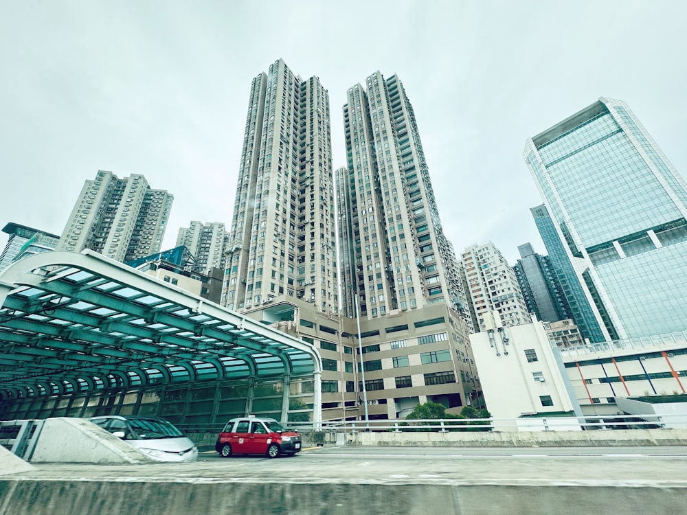 a red car is parked in front of some tall buildings