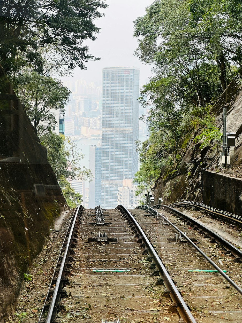 a train track with a tall building in the background