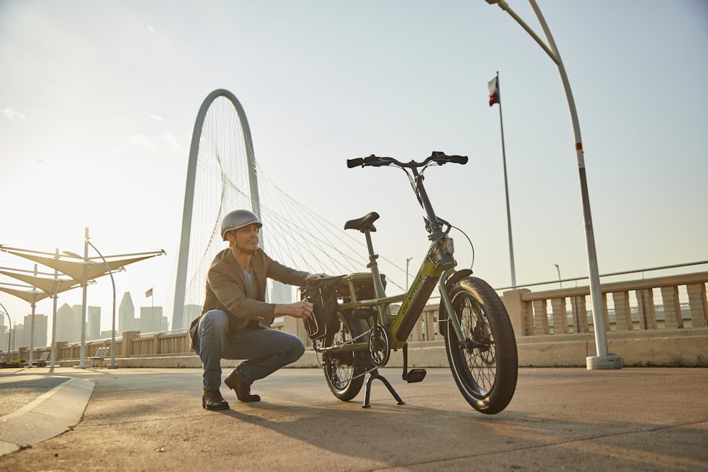 a woman kneeling down next to a bike