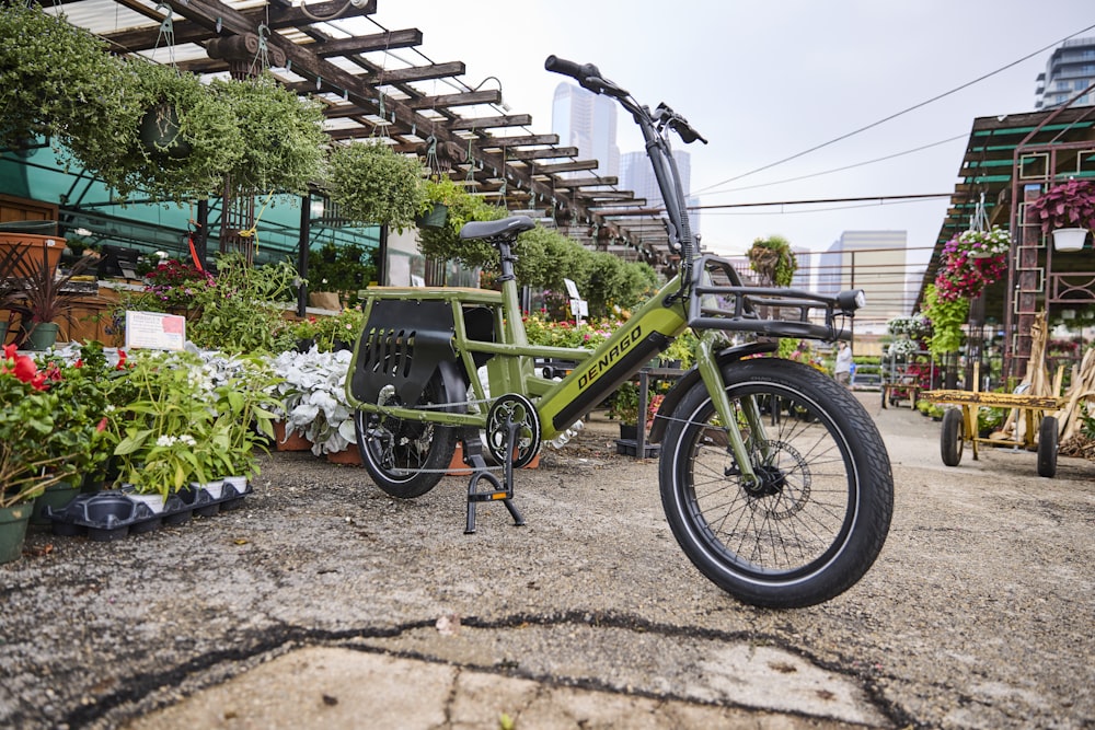 a green bike parked next to a bunch of flowers