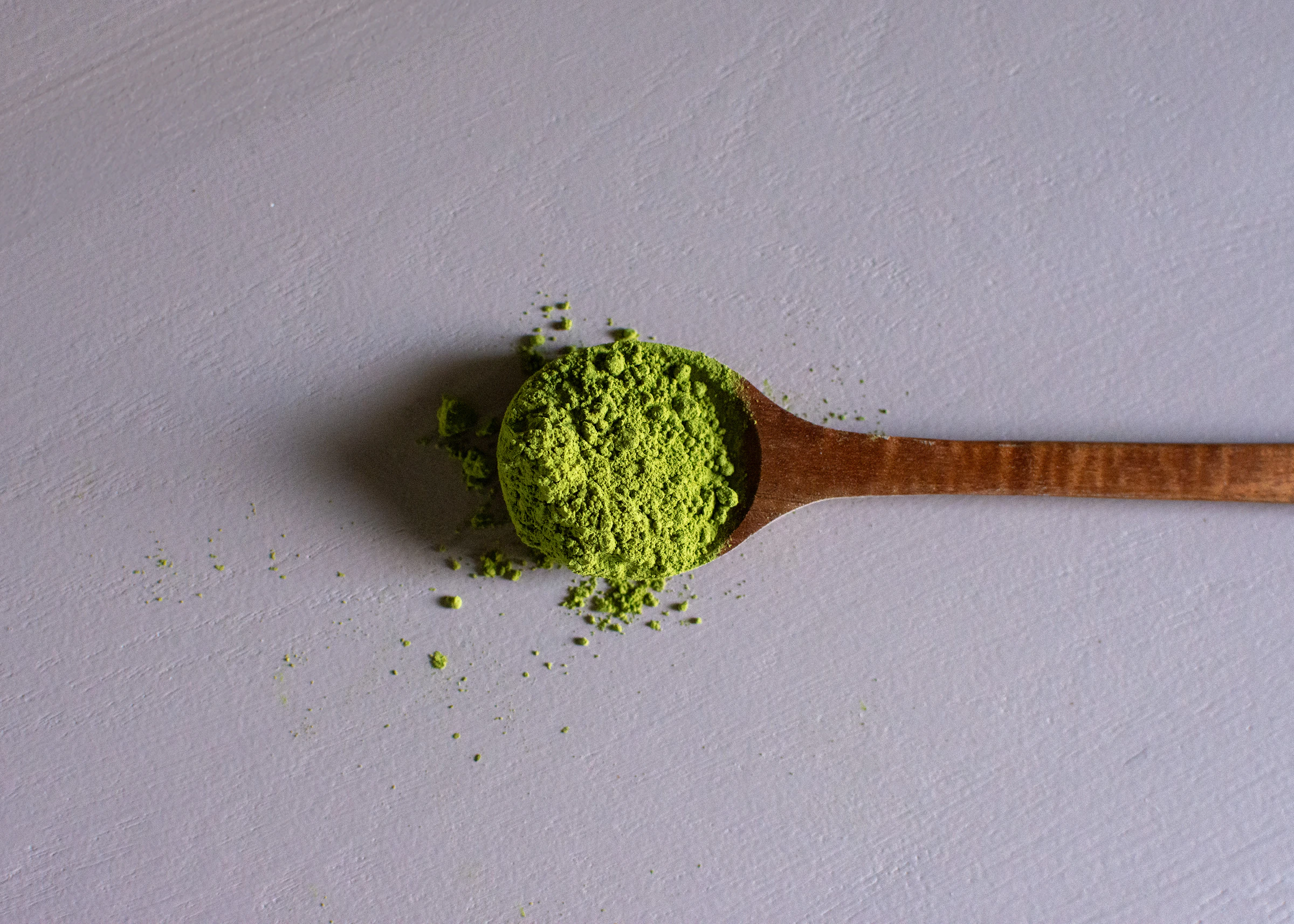 Holzlöffel mit frischem grünem Matcha-Pulver