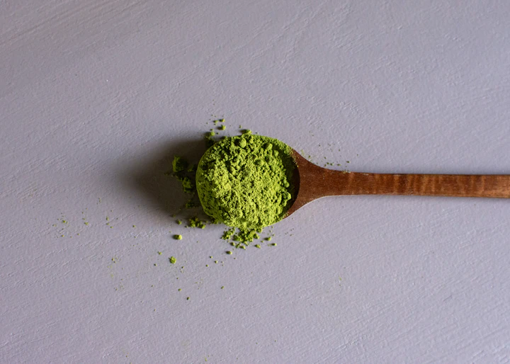 Matcha powder on a wooden spoon — visual inspiration for Matcha Iced Latte Coffee