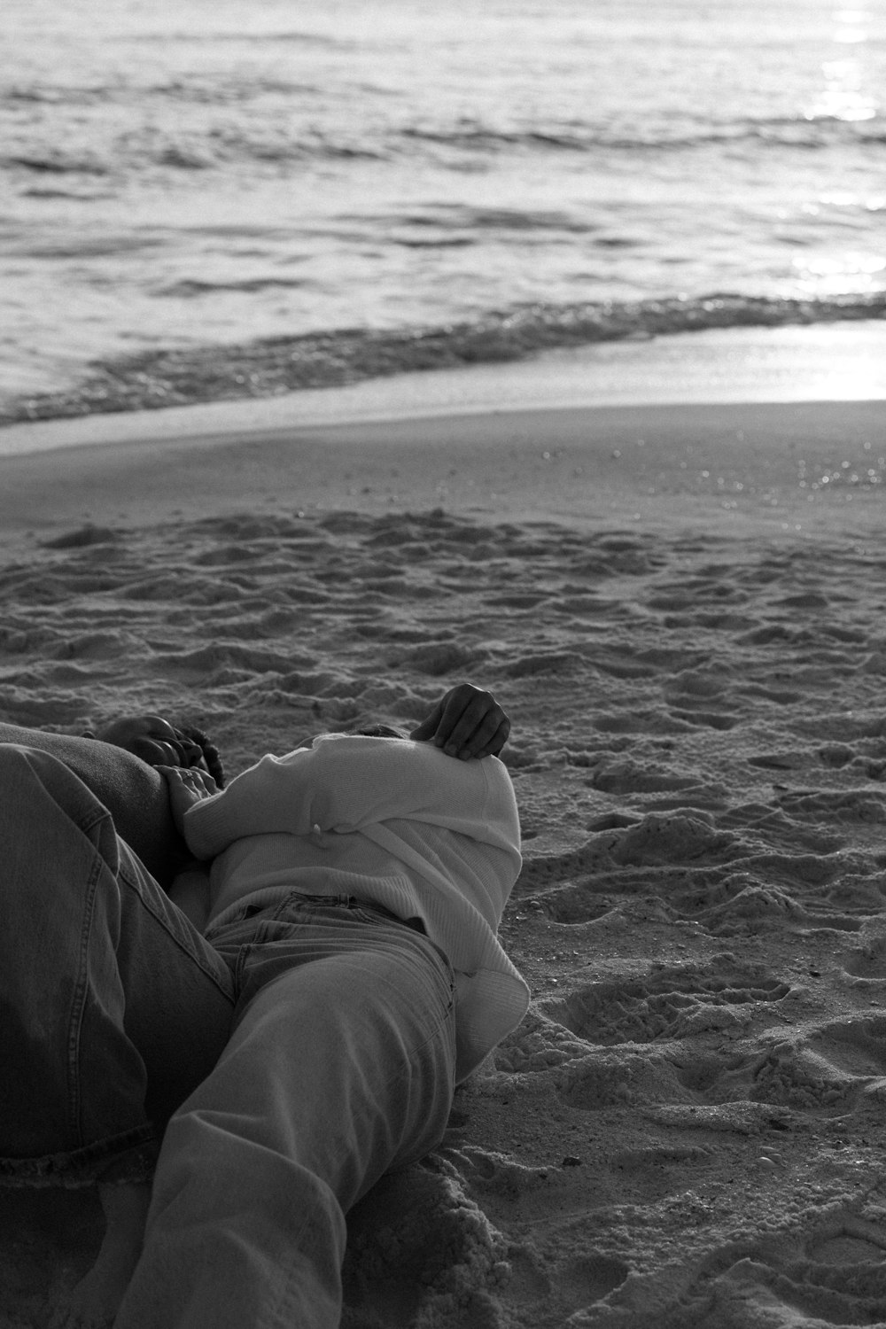 a person laying in the sand on the beach