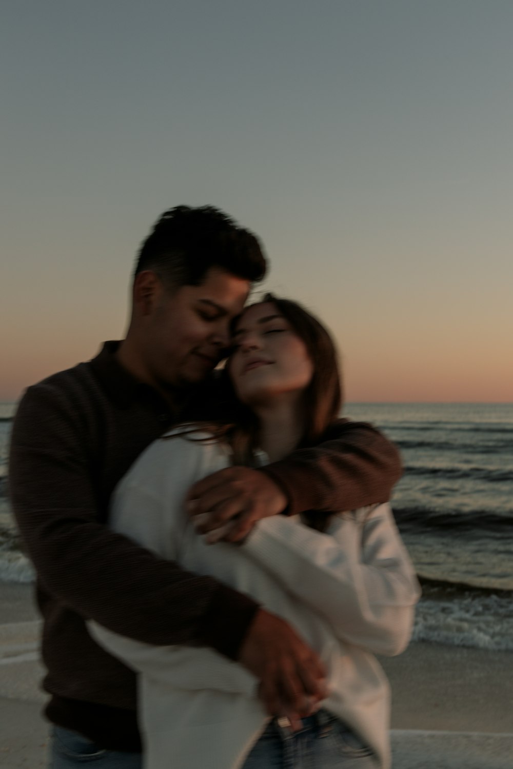 a man and a woman embracing on the beach