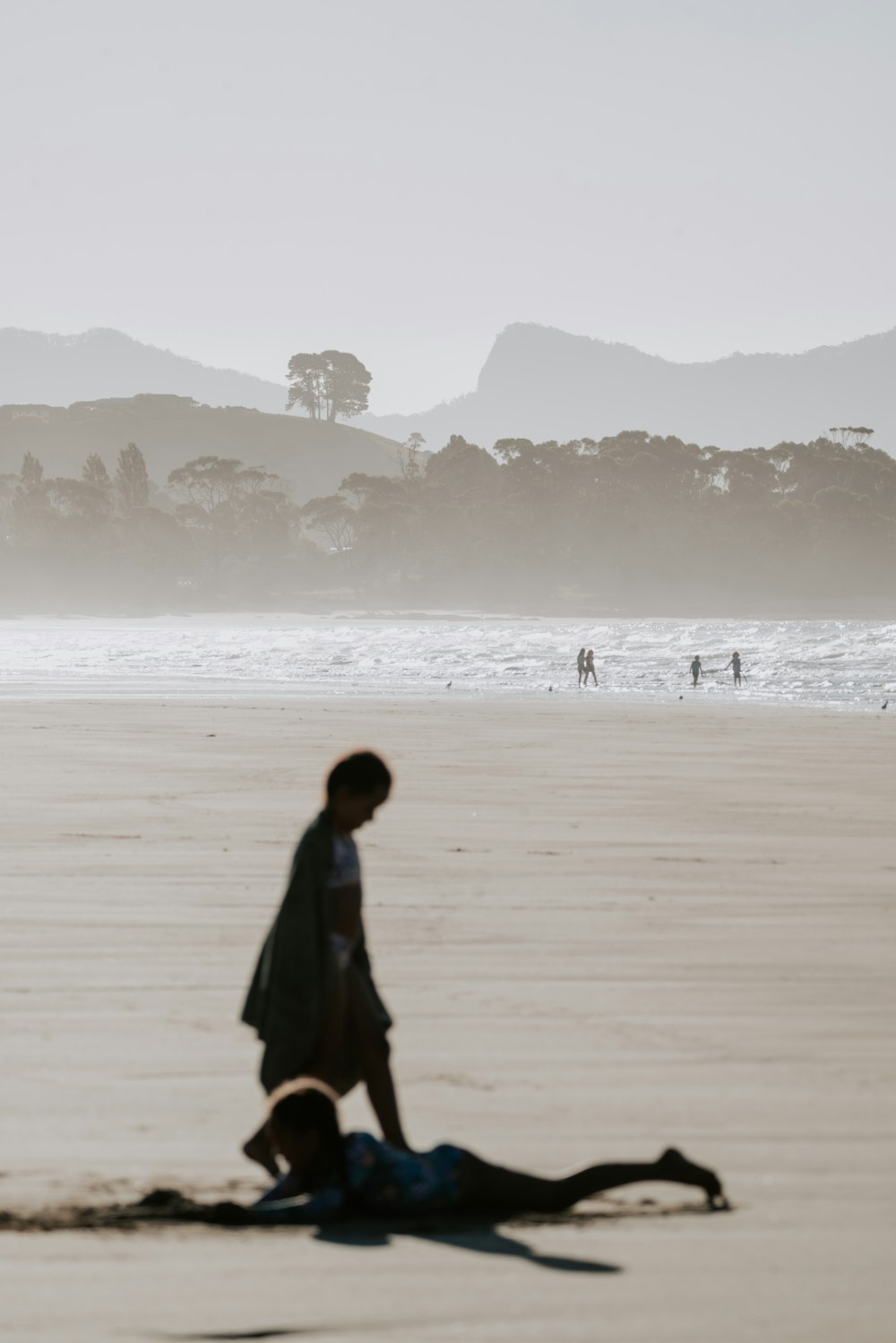 a person laying on a beach next to the ocean