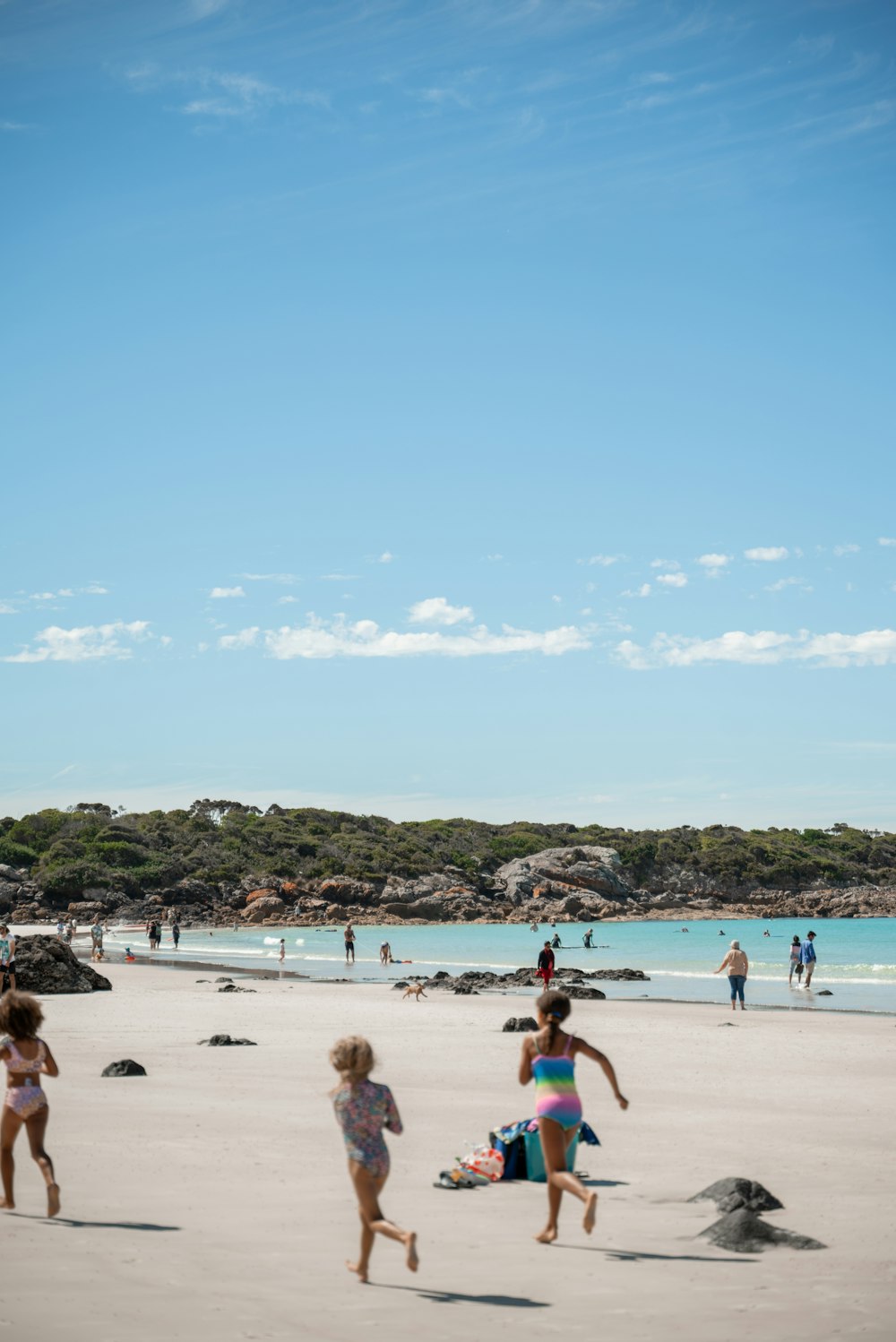 a group of people on a beach flying a kite