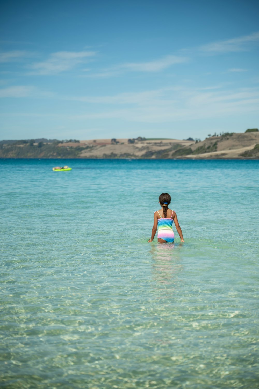 a woman standing in the ocean with a boogie board