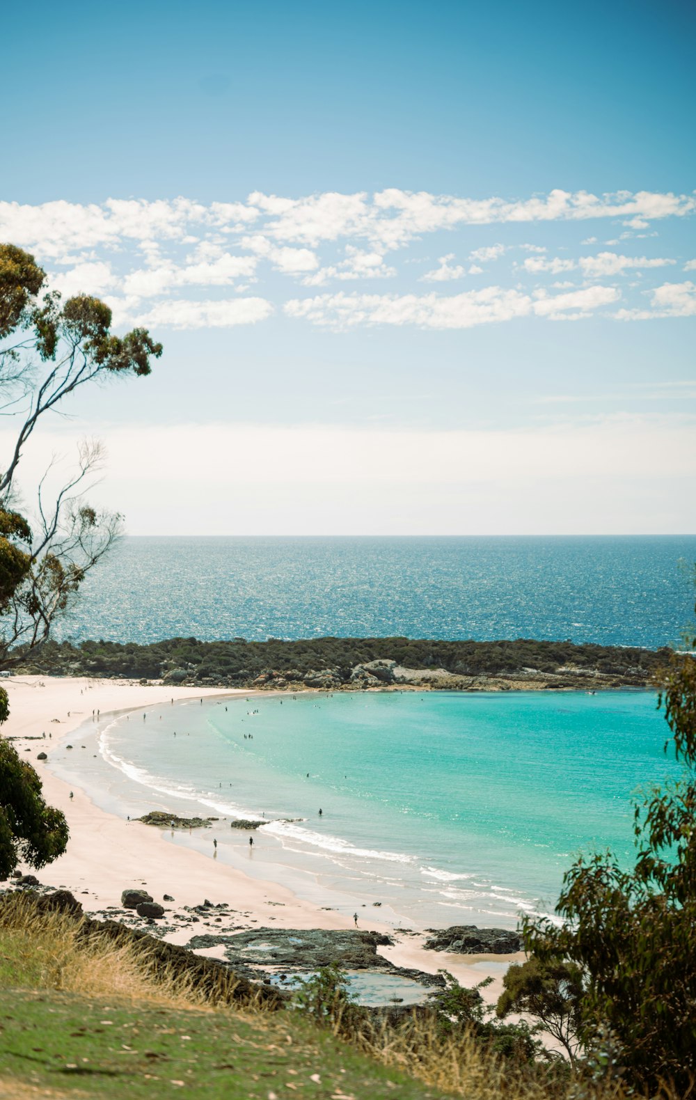 a view of a beach from a hill overlooking the ocean