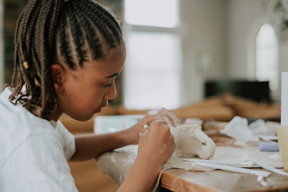 a young girl is making a stuffed animal