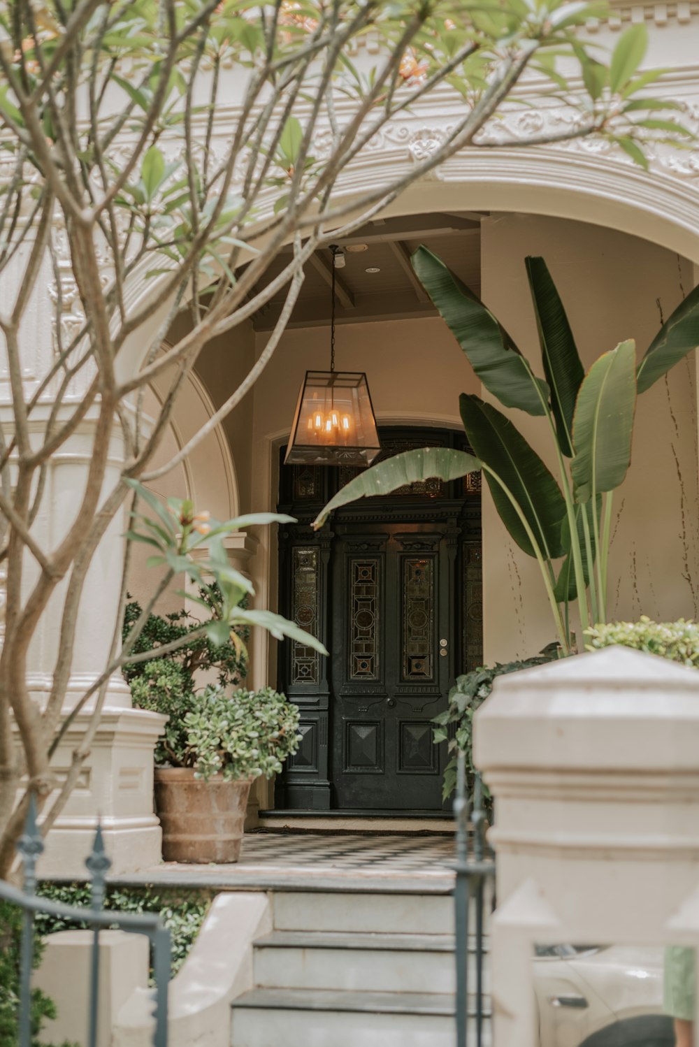 a house with a black door and some plants