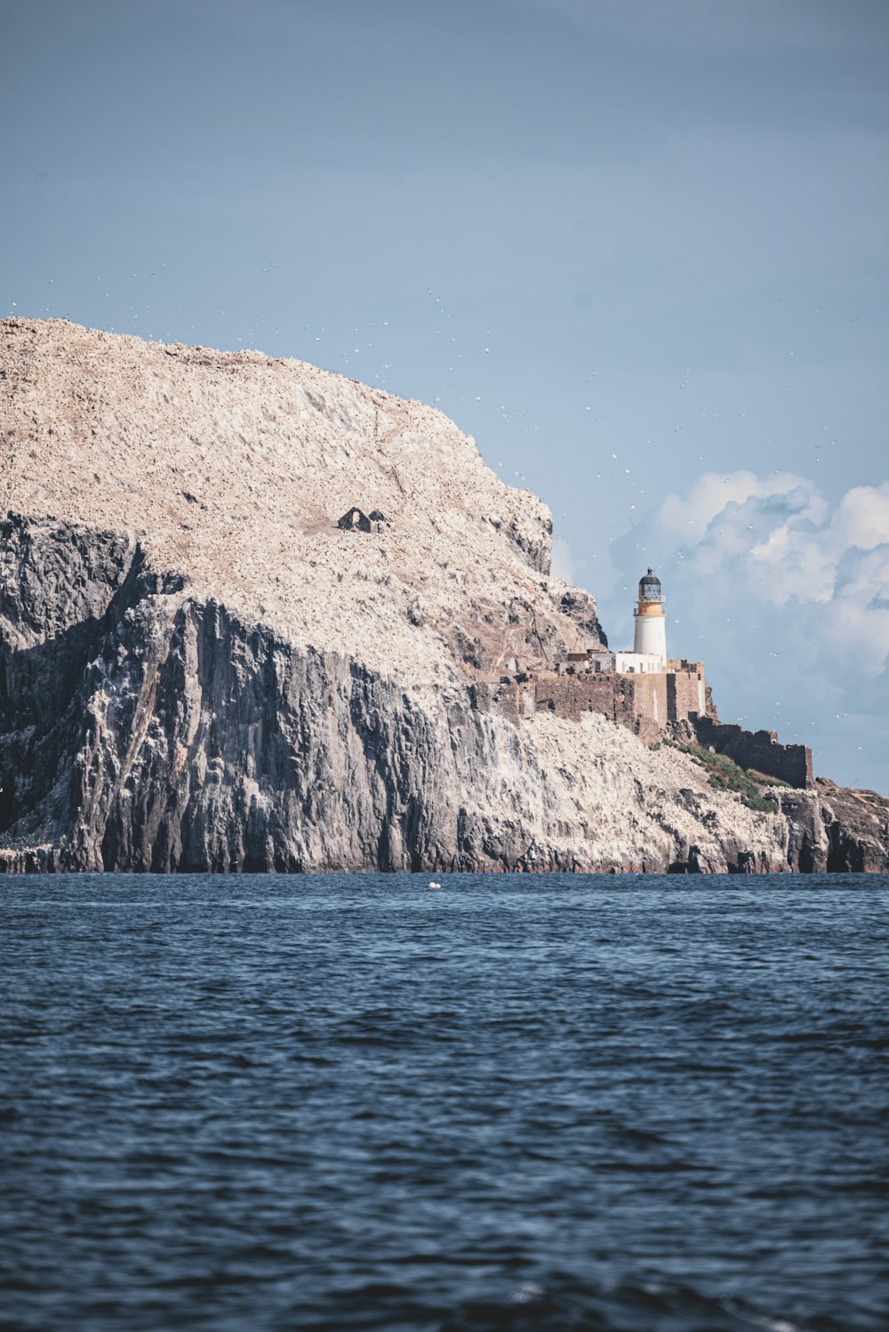 a lighthouse on top of a rocky outcropping
