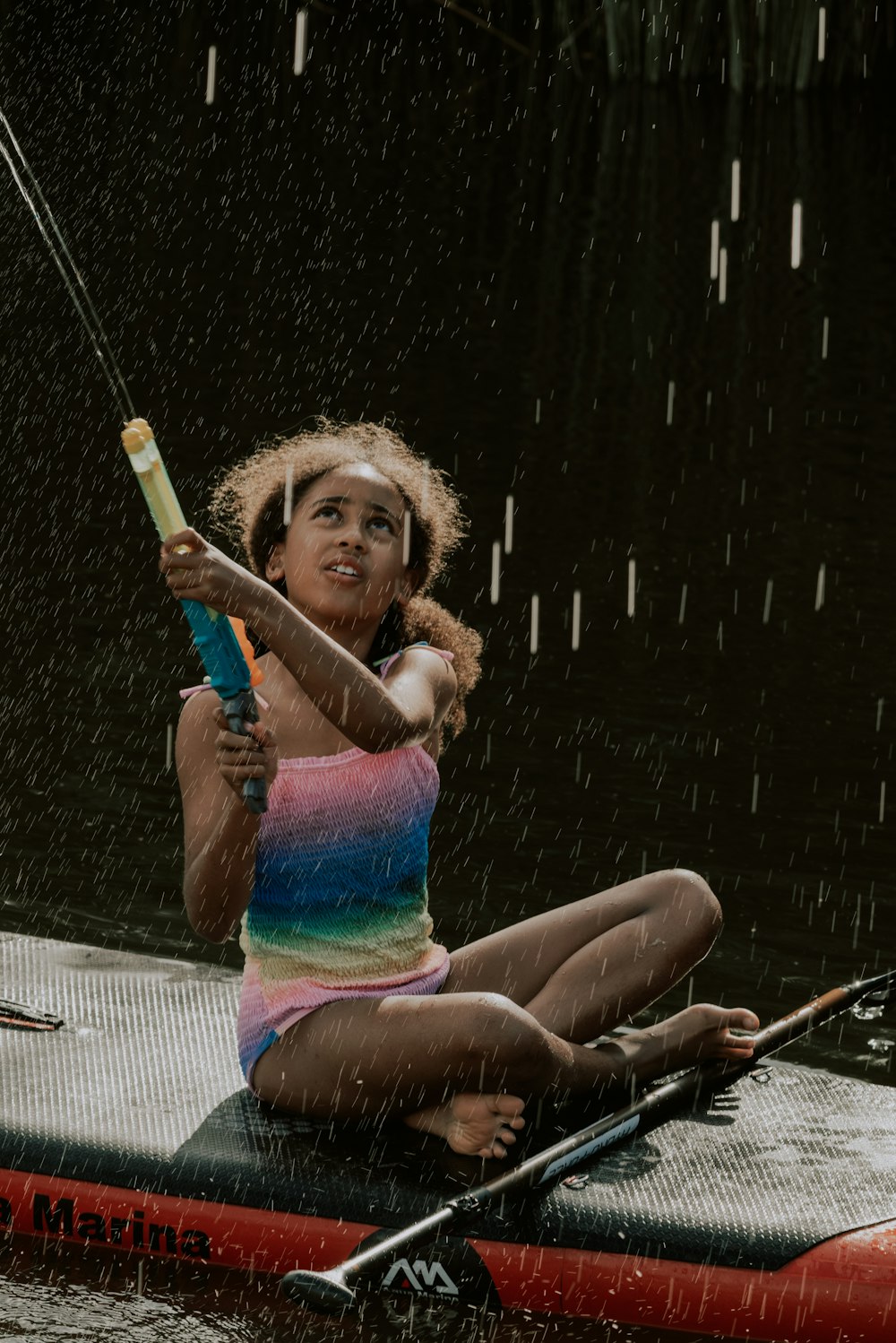 a woman sitting on a kayak in the rain