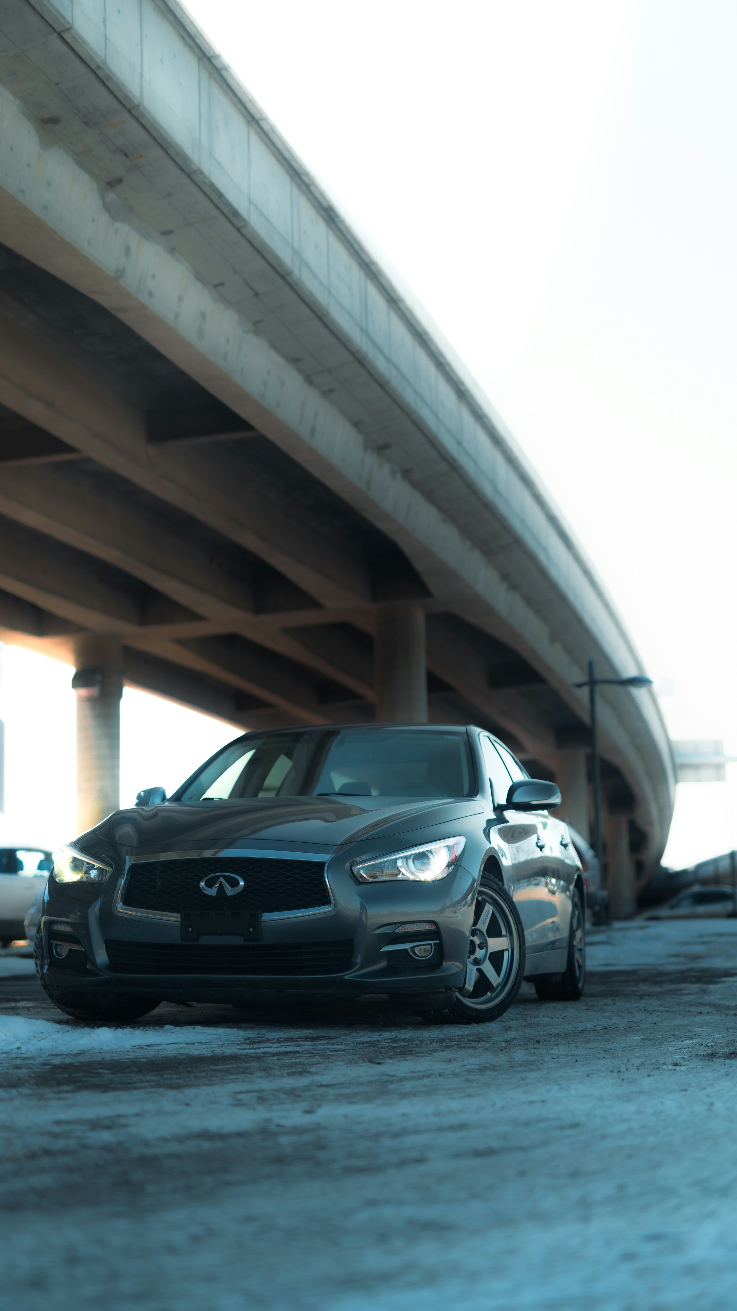 a black car parked in front of a bridge