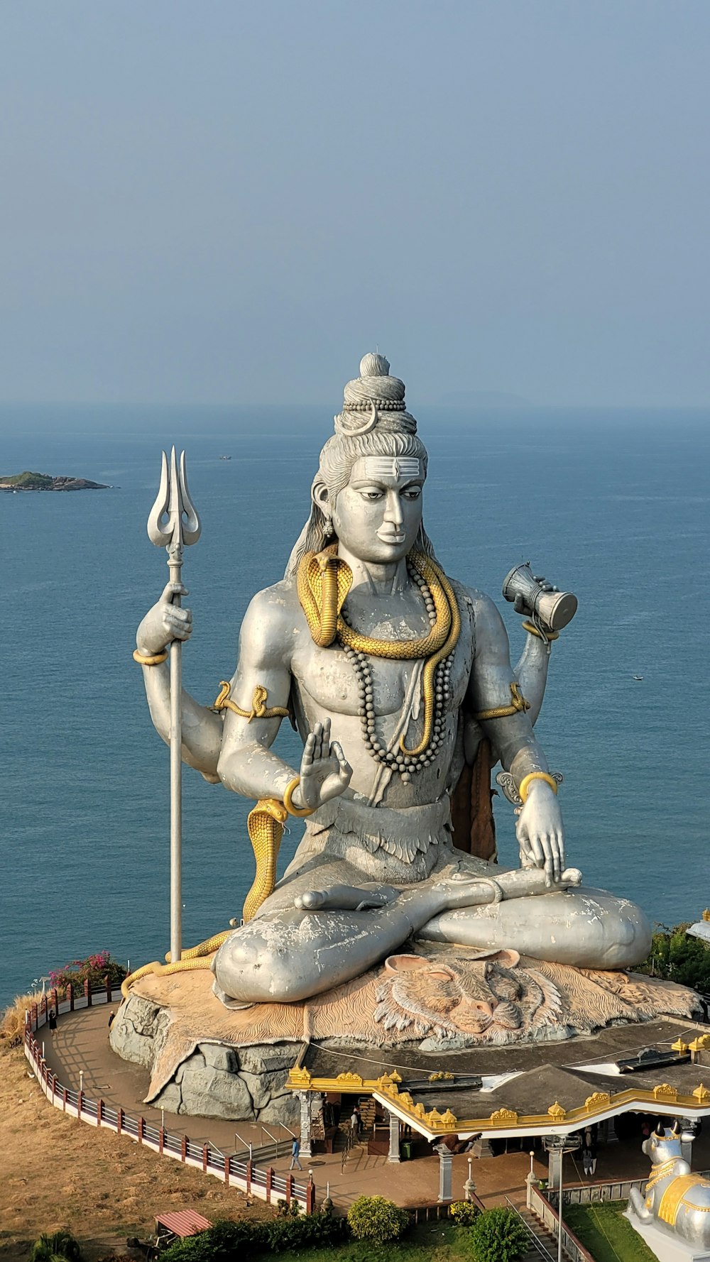 a statue of a person sitting on top of a body of water