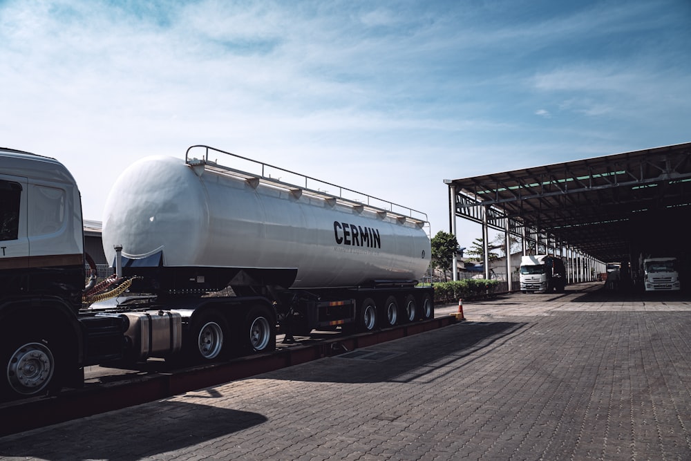 a white tanker truck parked in a parking lot