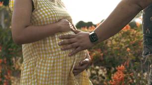 a pregnant woman holding the belly of a man