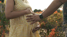 a pregnant woman holding the belly of a man