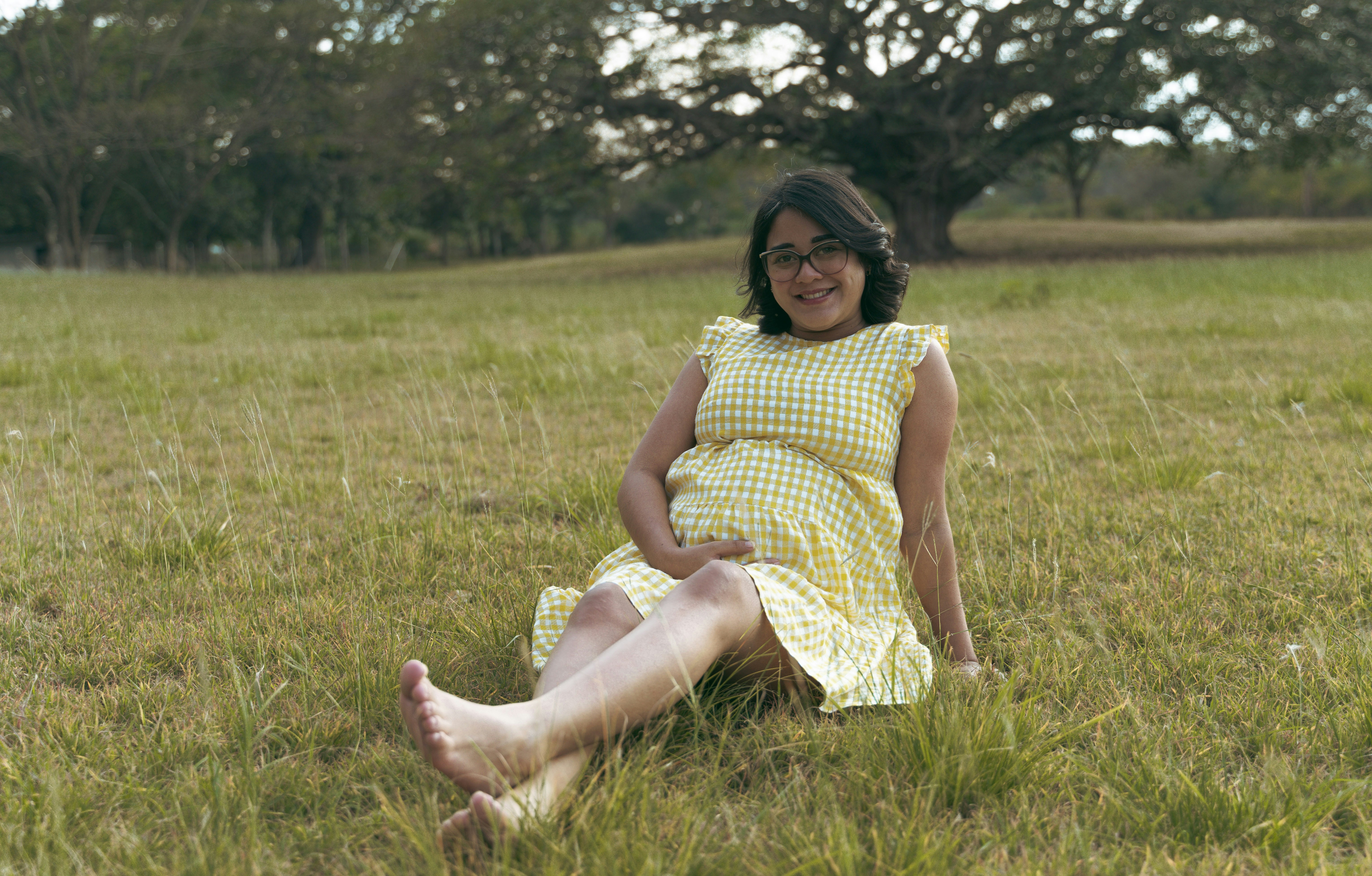 a woman in a yellow dress sitting in a field