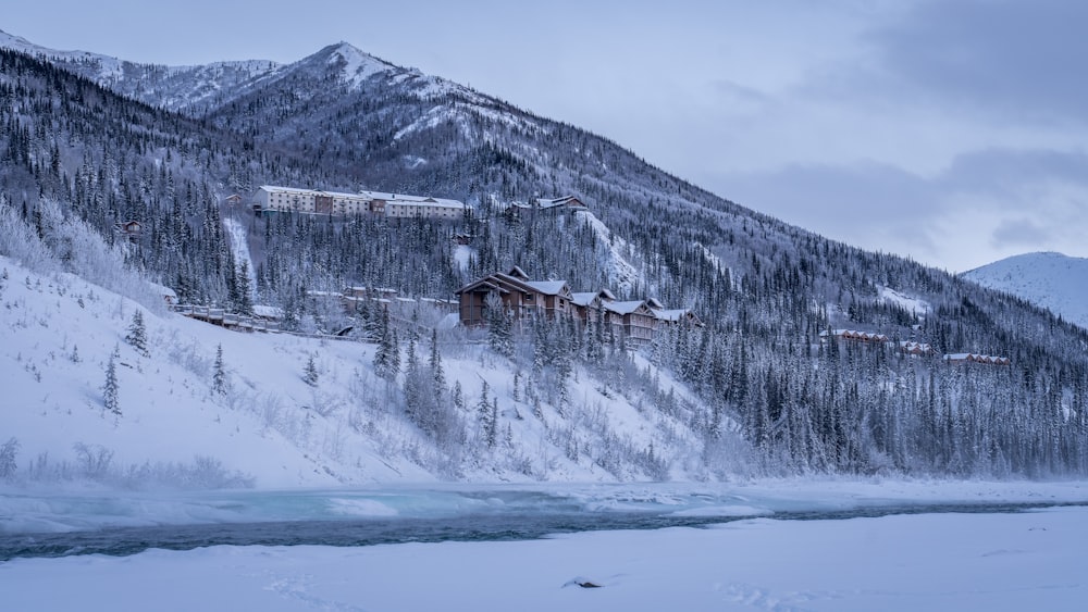 a snowy mountain with a lodge in the distance