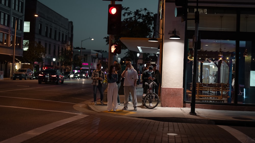 a group of people standing on a street corner