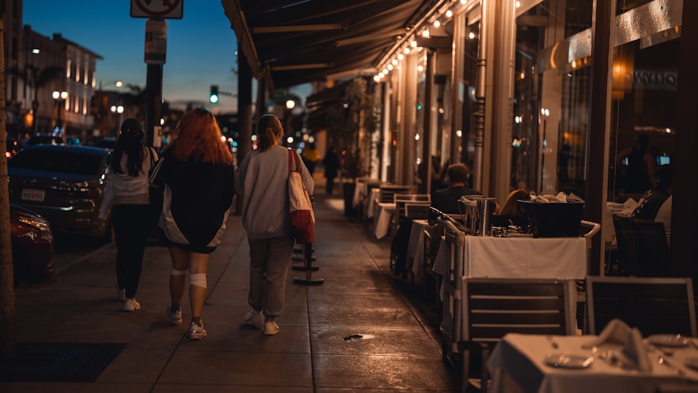 a couple of people walking down a sidewalk