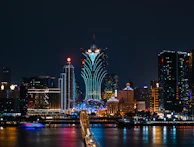 a city skyline at night with a bridge going across it