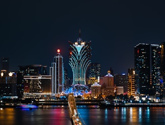 a city skyline at night with a bridge going across it