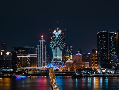 a city skyline at night with a bridge going across it