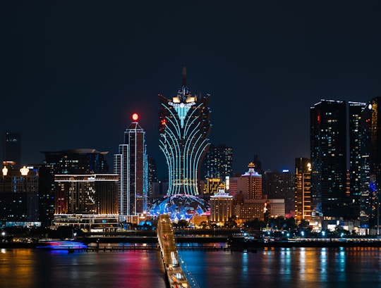 a city skyline at night with a bridge going across it