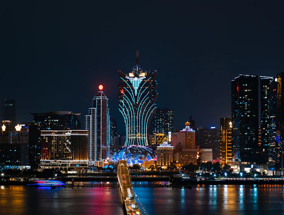 a city skyline at night with a bridge going across it